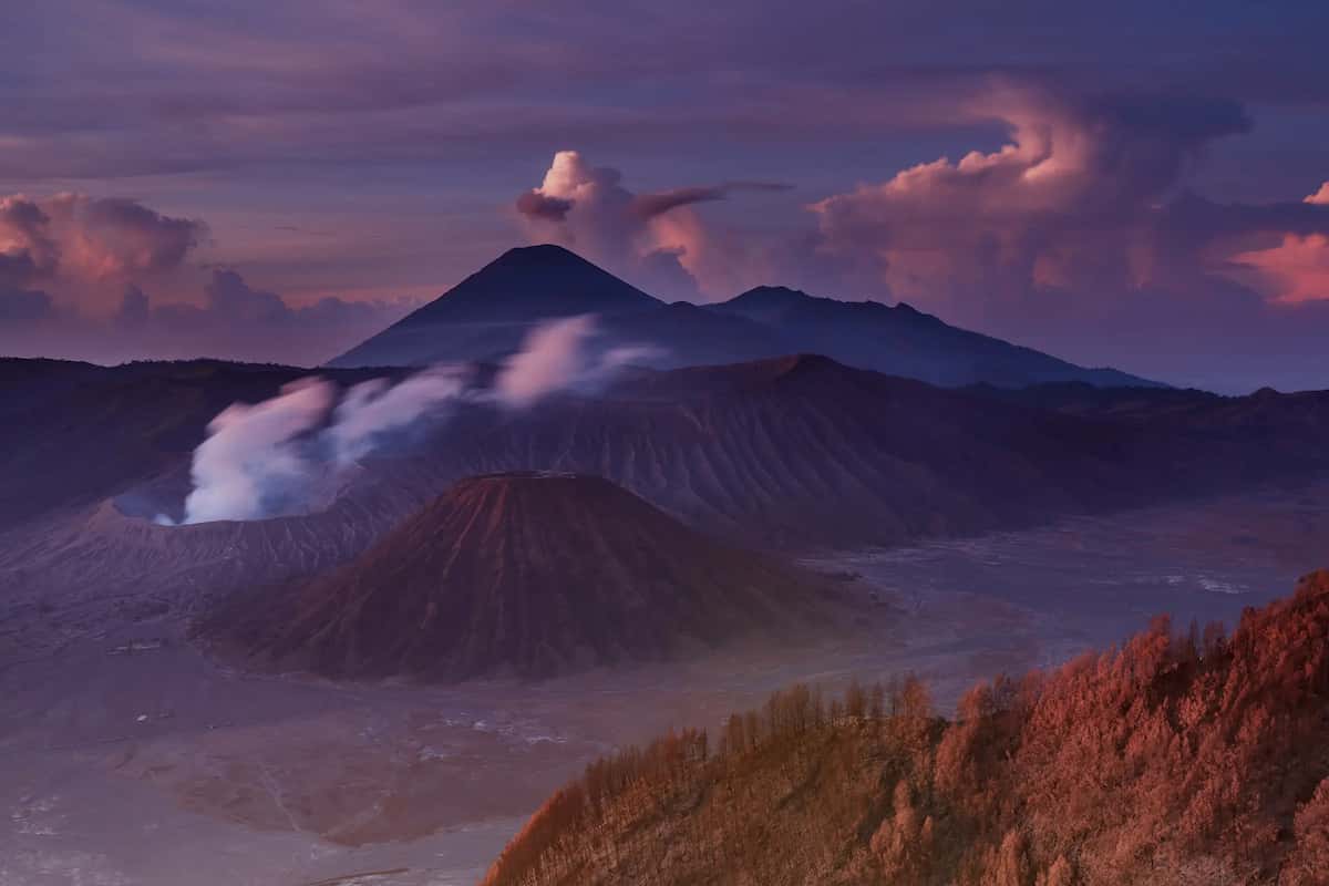 Kaldera Tengger saat fajar: kawah Bromo berasap, kerucut Gunung Batok, dan Semeru di kejauhan