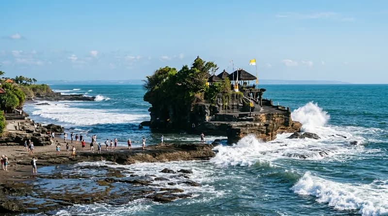 Pura Tanah Lot di atas batu karang dengan latar laut biru di Bali