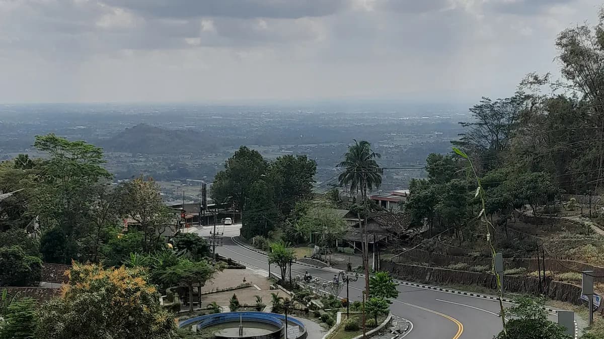 Tikungan Jalan Raya Jogja-Wonosari di tanjakan Pathuk dengan dataran Yogyakarta terlihat di kejauhan pada siang hari
