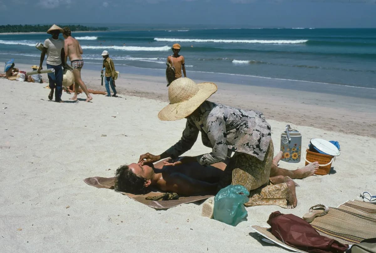 Pantai Kuta pada 1981 dengan pemijat pantai, pedagang asongan, dan wisatawan berjemur di pasir