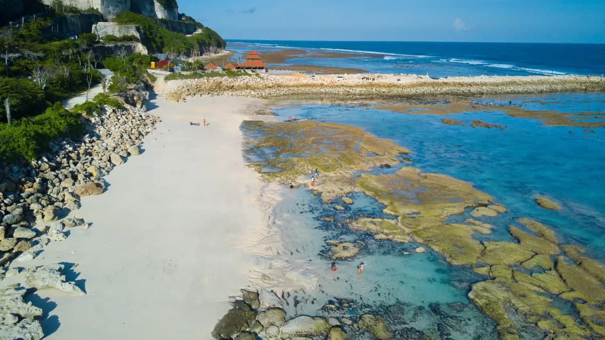 Tebing kapur putih dan air toska dangkal di Pantai Melasti, Ungasan, Bali