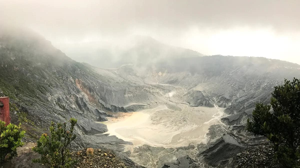 Kawah Ratu di Gunung Tangkuban Perahu dilihat dari bibir kawah, dengan dinding kawah kelabu dan uap belerang