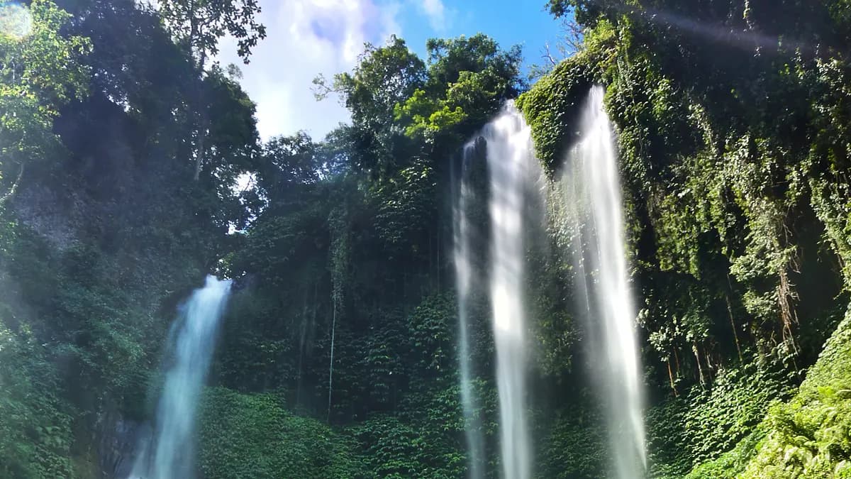 Dua tirai Air Terjun Sekumpul jatuh dari tebing berlumut hijau di Buleleng, Bali