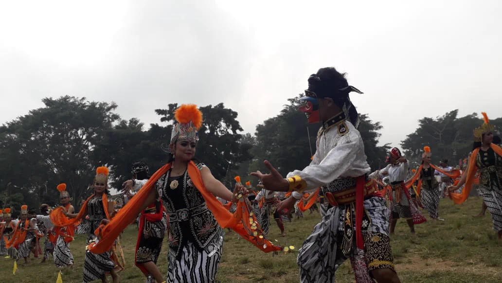 Puluhan penari berkostum batik dan selendang oranye menarikan Topeng Lengger serentak di lapangan rumput Alun-alun Wonosobo