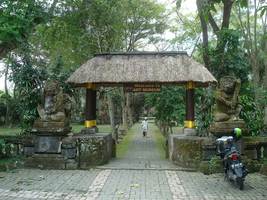 Gerbang bertuliskan Welcome to ARMA Art Museum dengan jalan setapak berpaving menuju area museum
