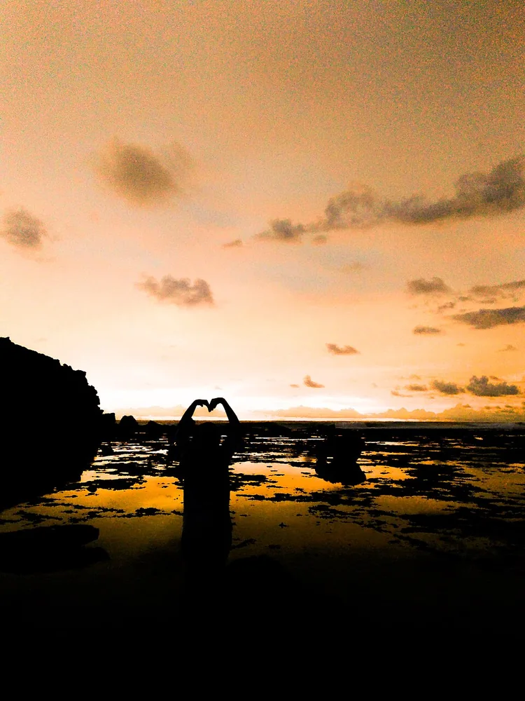 Siluet pengunjung saat senja di Pantai Watu Karung, Pacitan