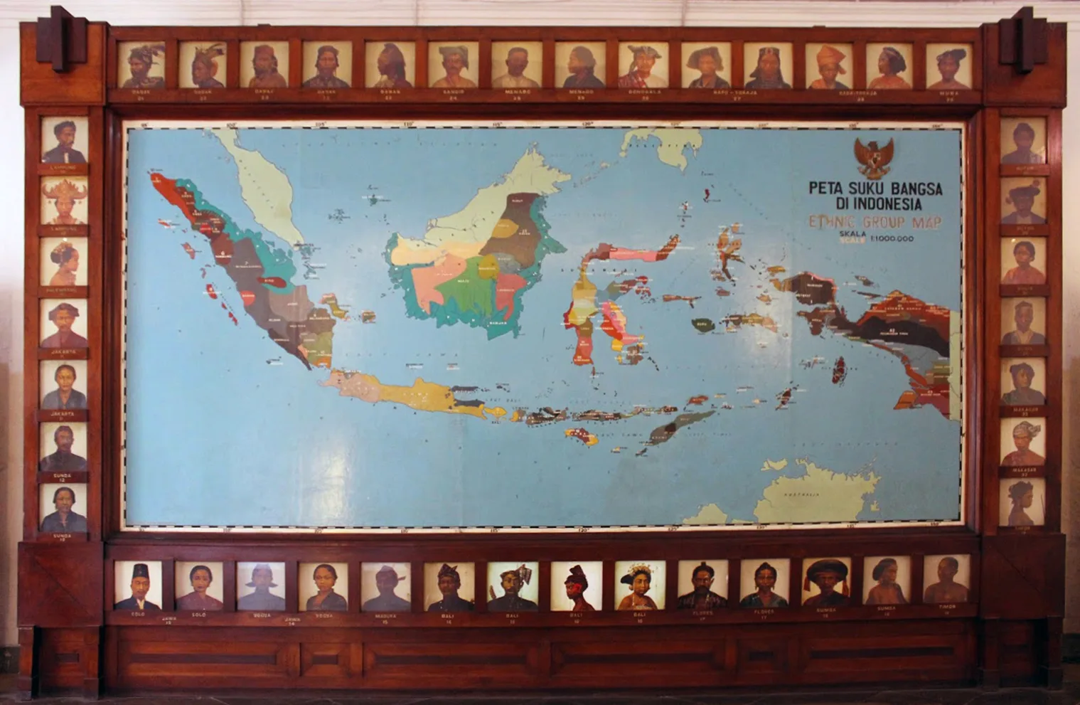 Panel Peta Suku Bangsa di Indonesia berbingkai kayu di ruang etnologi Museum Nasional, dikelilingi puluhan potret kelompok etnis