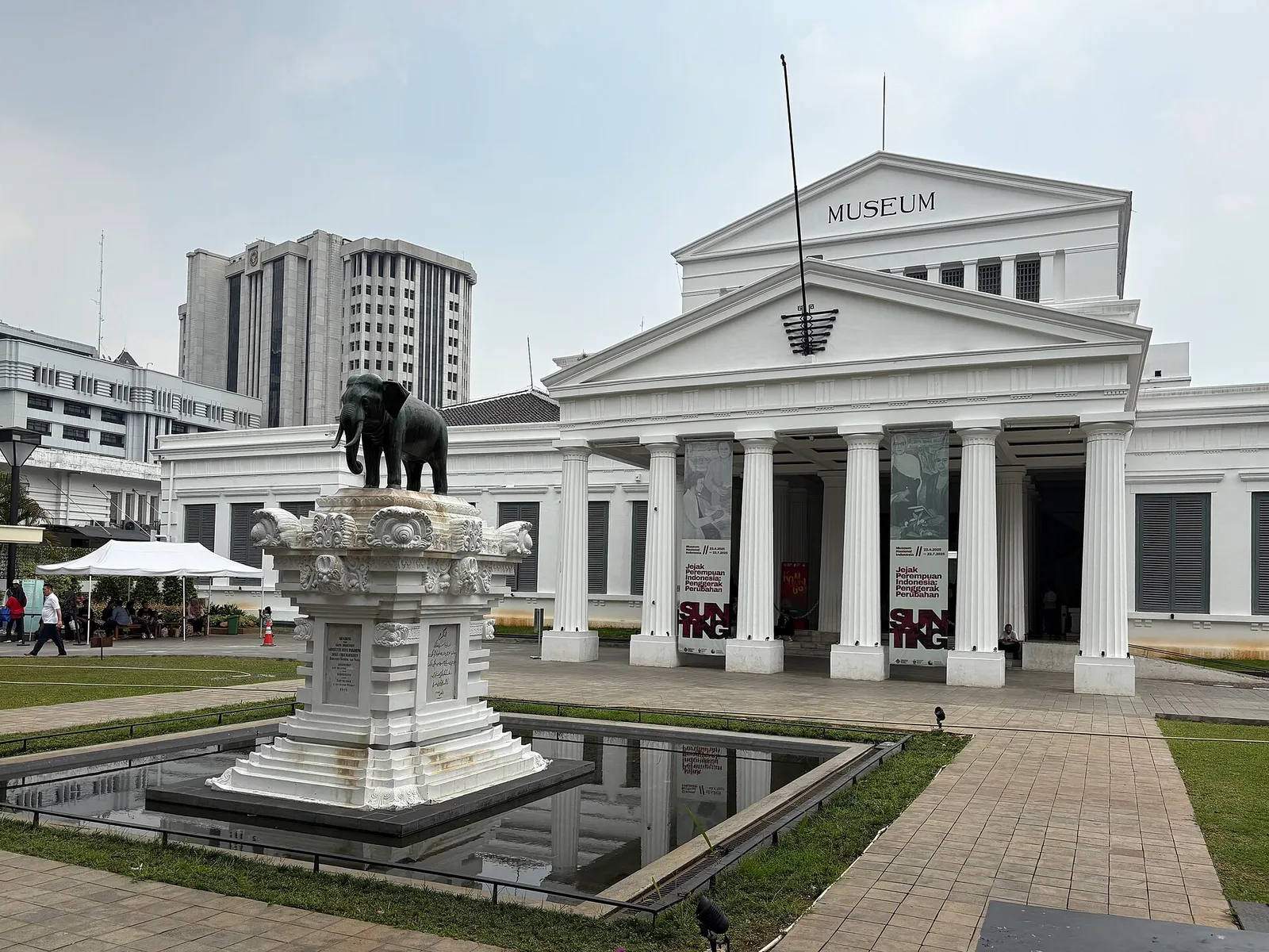 Fasad Gedung Gajah Museum Nasional Indonesia dengan patung gajah perunggu di atas kolam halaman depan