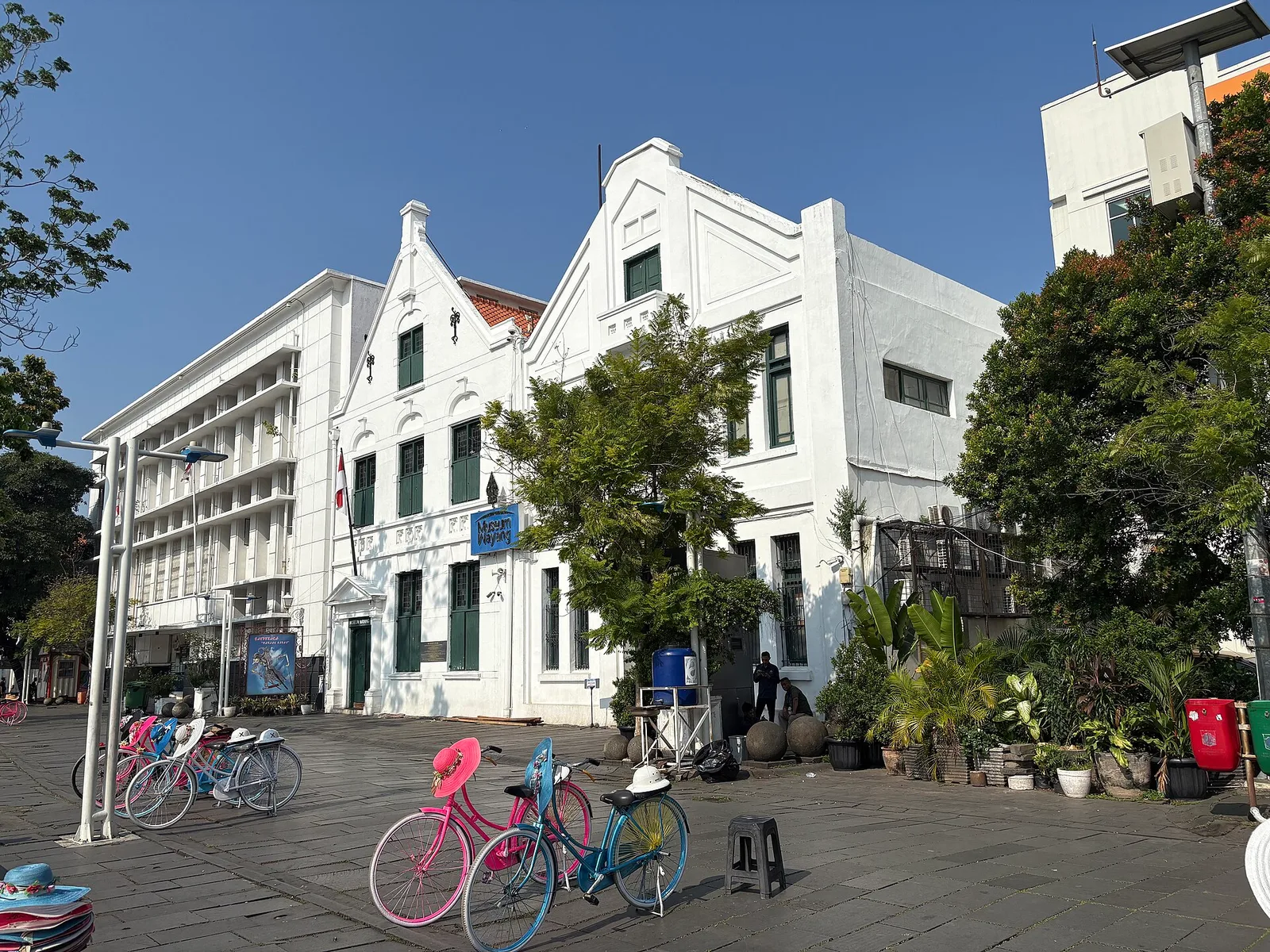 Pelataran berbatu Taman Fatahillah di depan Museum Wayang dengan sepeda ontel sewaan berwarna merah muda dan biru berjajar