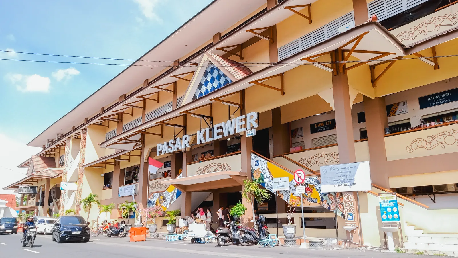 Fasad gedung Pasar Klewer Solo dengan papan nama besar dan deretan sepeda motor terparkir di trotoar depannya
