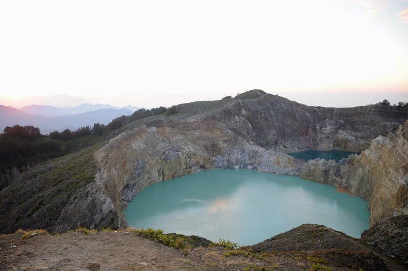 Dua danau kawah Kelimutu dilihat dari tepi kaldera pada pagi hari