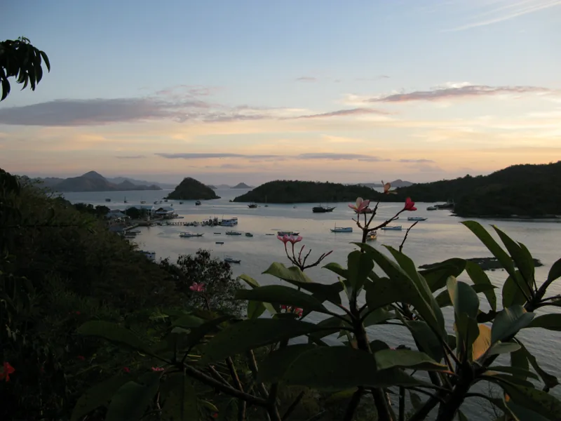 Teluk Labuan Bajo saat senja dengan perahu-perahu berlabuh dan deretan pulau di kejauhan