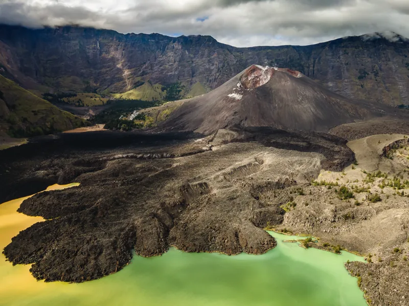 Pandangan udara ke Gunung Barujari, aliran lava, dan Danau Segara Anak di dalam kaldera Rinjani