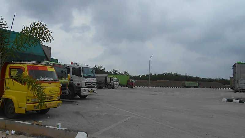 Area parkir rest area di jalan tol Trans-Sumatra dengan beberapa truk terparkir