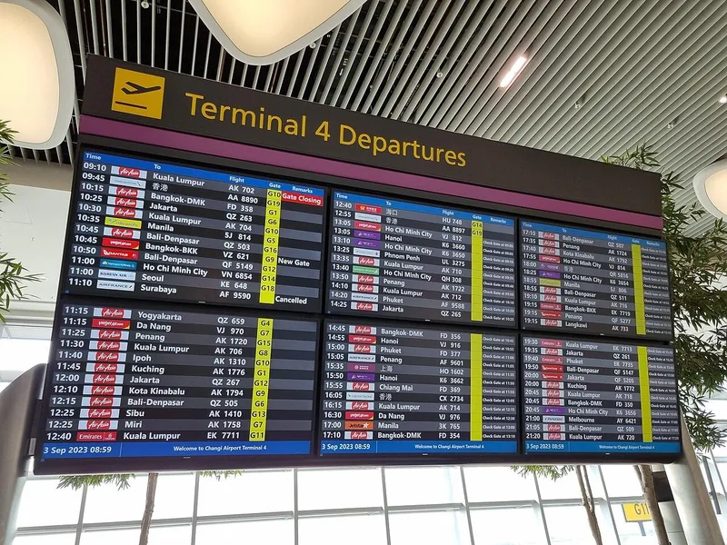 Layar jadwal keberangkatan Terminal 4 Bandara Changi berisi kolom jam, tujuan, nomor penerbangan, gerbang, dan keterangan
