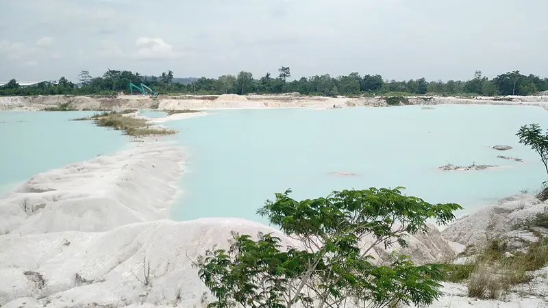 Danau Kaolin Belitung berair biru toska dikelilingi gundukan tanah kaolin putih dan pepohonan