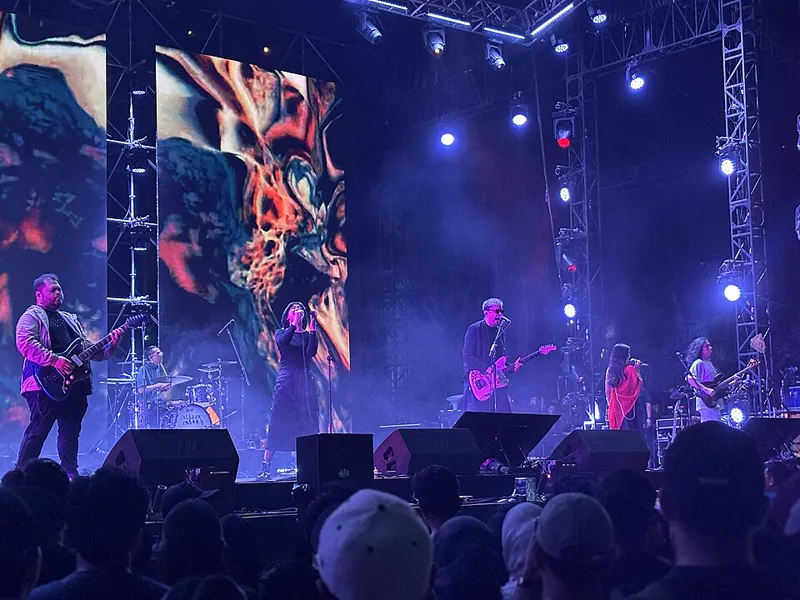 Band Barasuara tampil di panggung Synchronize Fest dengan layar besar dan lampu sorot, penonton memadati depan panggung