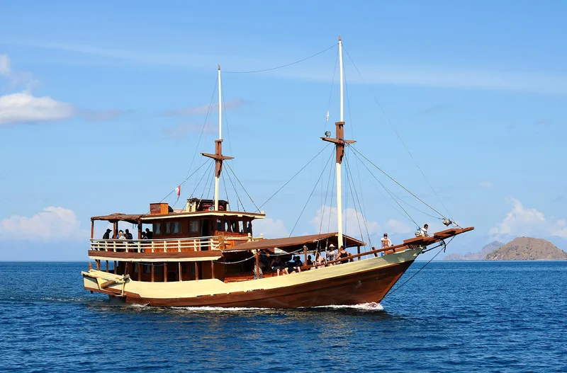 Kapal wisata pinisi Pasolle berlayar membawa penumpang di perairan Pulau Komodo