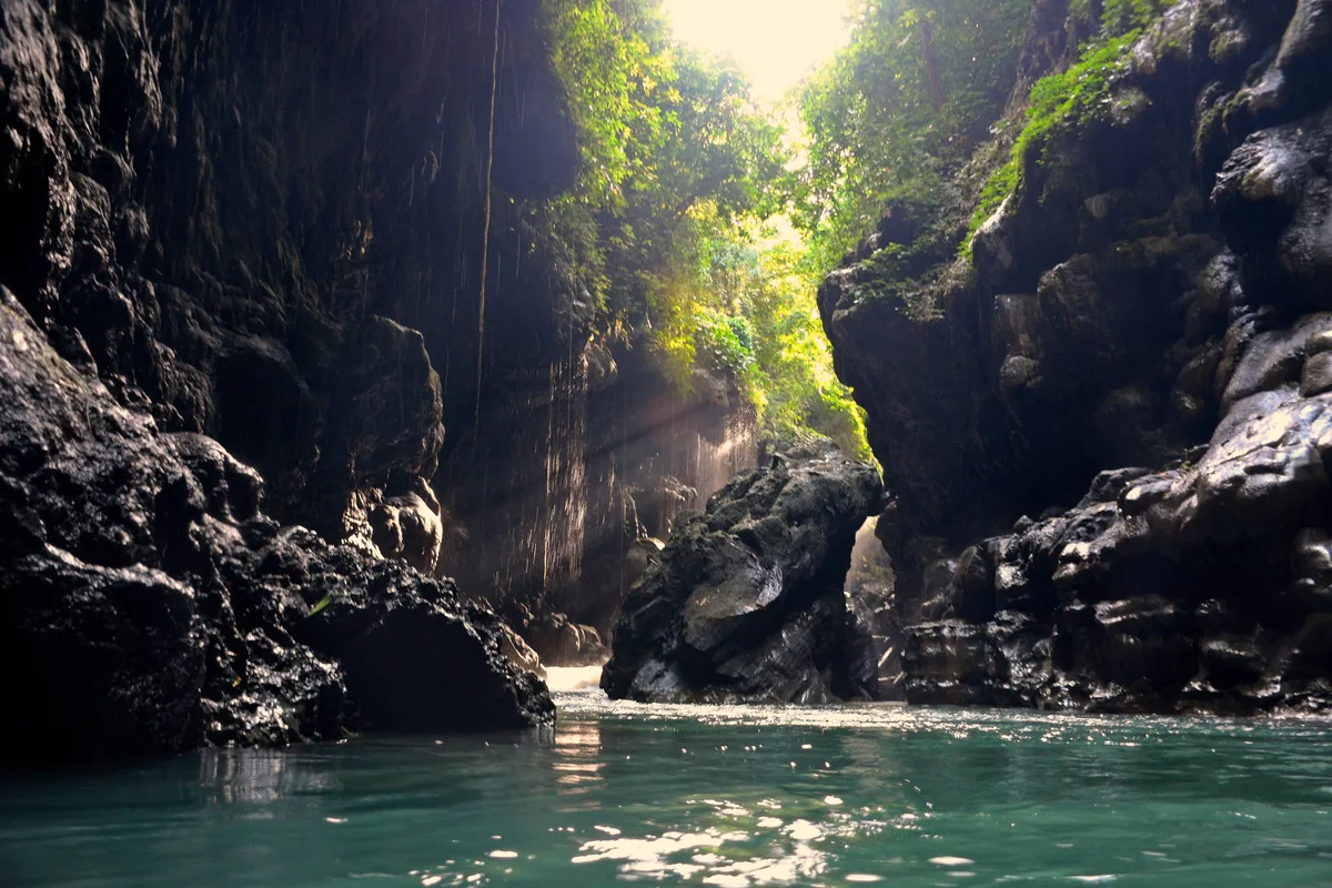 Lorong sempit Cukang Taneuh atau Green Canyon dengan air hijau tosca di antara dinding batu basah