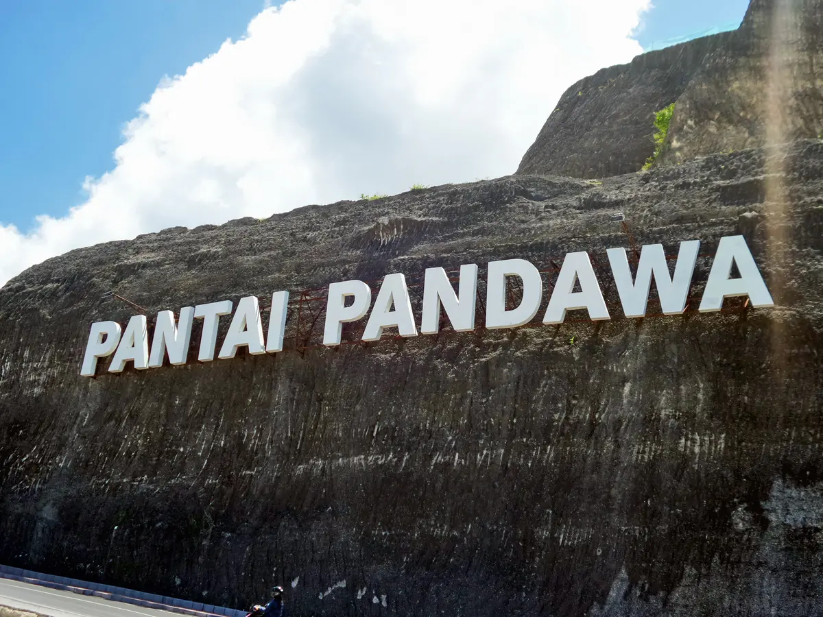 Tulisan PANTAI PANDAWA dipahat pada dinding tebing kapur di jalan masuk pantai