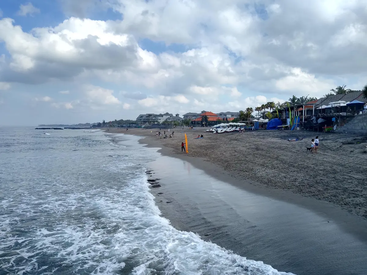 Garis Pantai Canggu dengan deretan bangunan dan warung di tepi pasir gelap