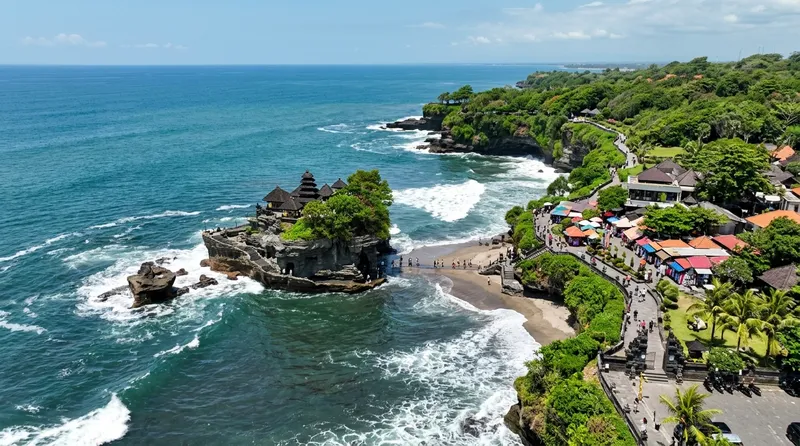 Pemandangan aerial kawasan Pura Tanah Lot Bali dengan batu karang, toko oleh-oleh, dan jalur menuju pura