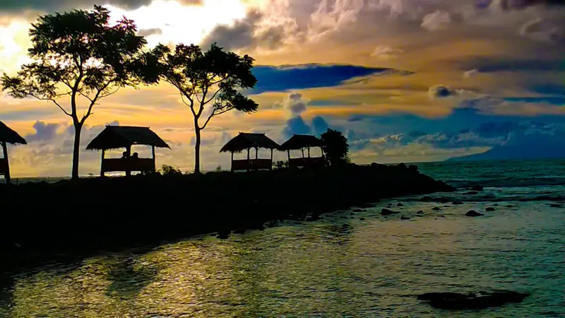 Pantai Anyer Banten dengan gazebo dan garis laut saat senja