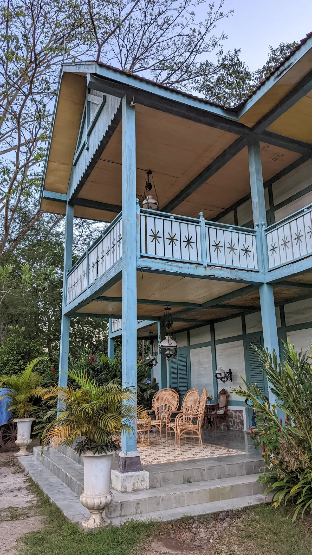 Rumah kayu bergaya kolonial bercat biru muda dengan beranda dua lantai di Studio Alam Gamplong