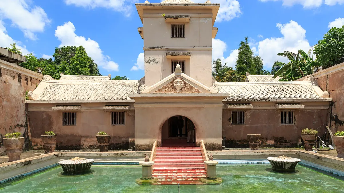 Kolam pemandian Taman Sari Yogyakarta dengan bangunan menara bertingkat dan tangga merah di tengah