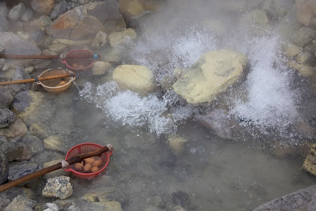 Sumber air panas mendidih di Kawah Domas, Tangkuban Perahu, dengan telur di keranjang bergagang bambu dan endapan belerang kuning