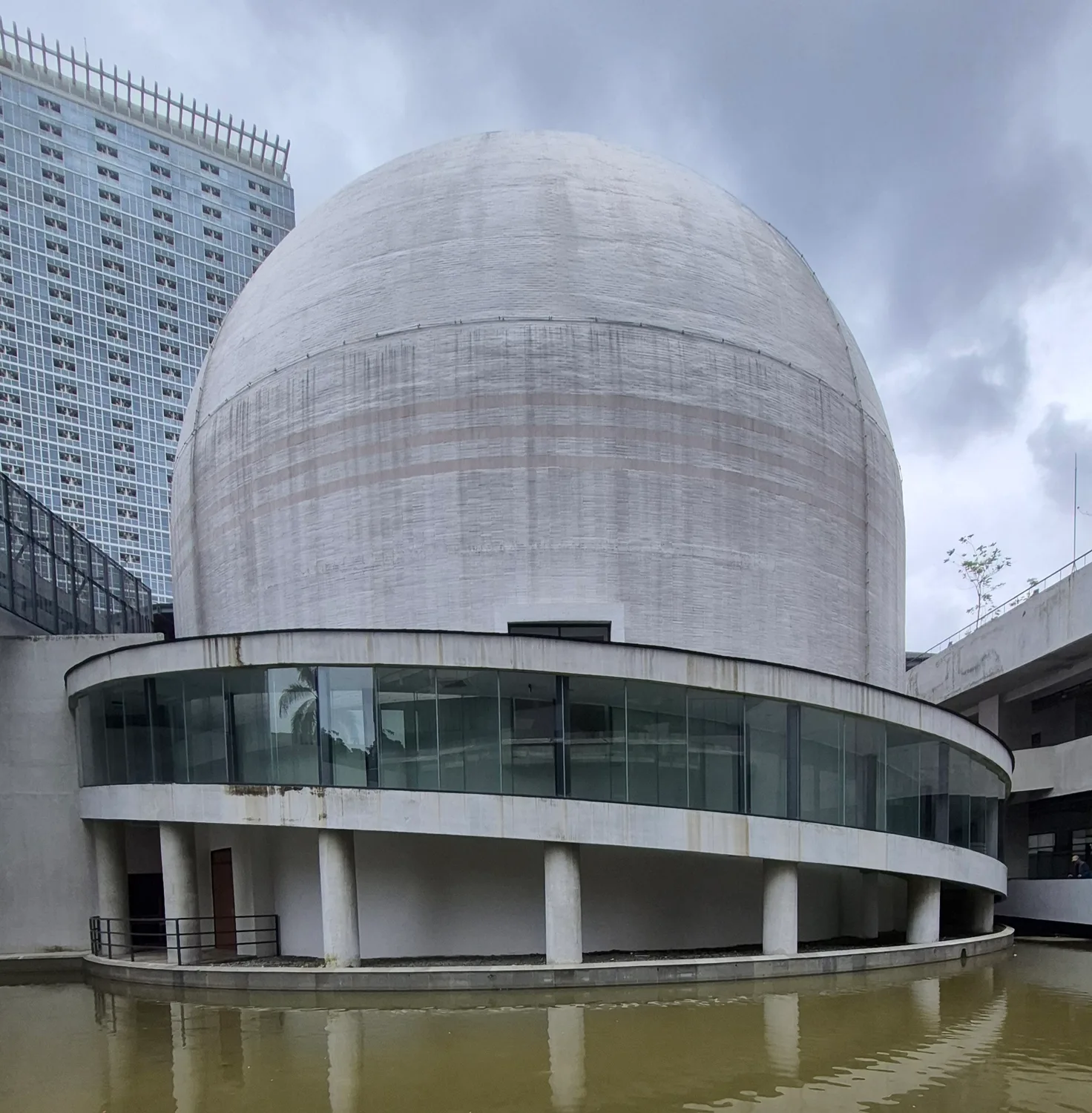 Kubah beton Planetarium dan Observatorium Jakarta di kompleks Taman Ismail Marzuki dengan kolam air di bagian depannya
