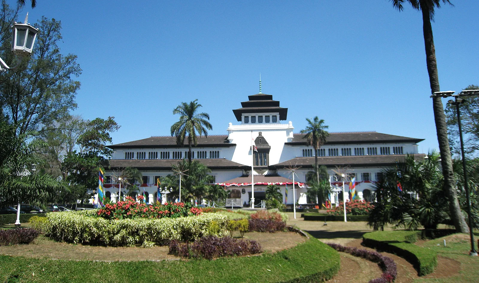 Gedung Sate di Bandung dengan menara berujung ornamen tusuk sate dan taman berbunga di halaman depan