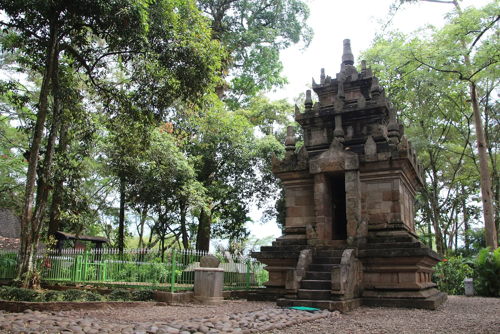Candi Cangkuang, candi batu kecil bergaya Hindu berundak dengan tangga masuk, berdiri di kompleks berpohon rindang di Leles, Garut