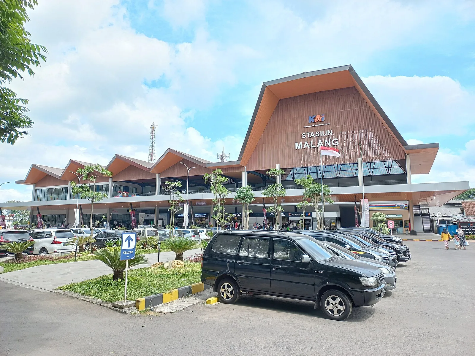 Bangunan baru Stasiun Malang sisi timur dengan atap kayu bertingkat dan area parkir kendaraan di depannya