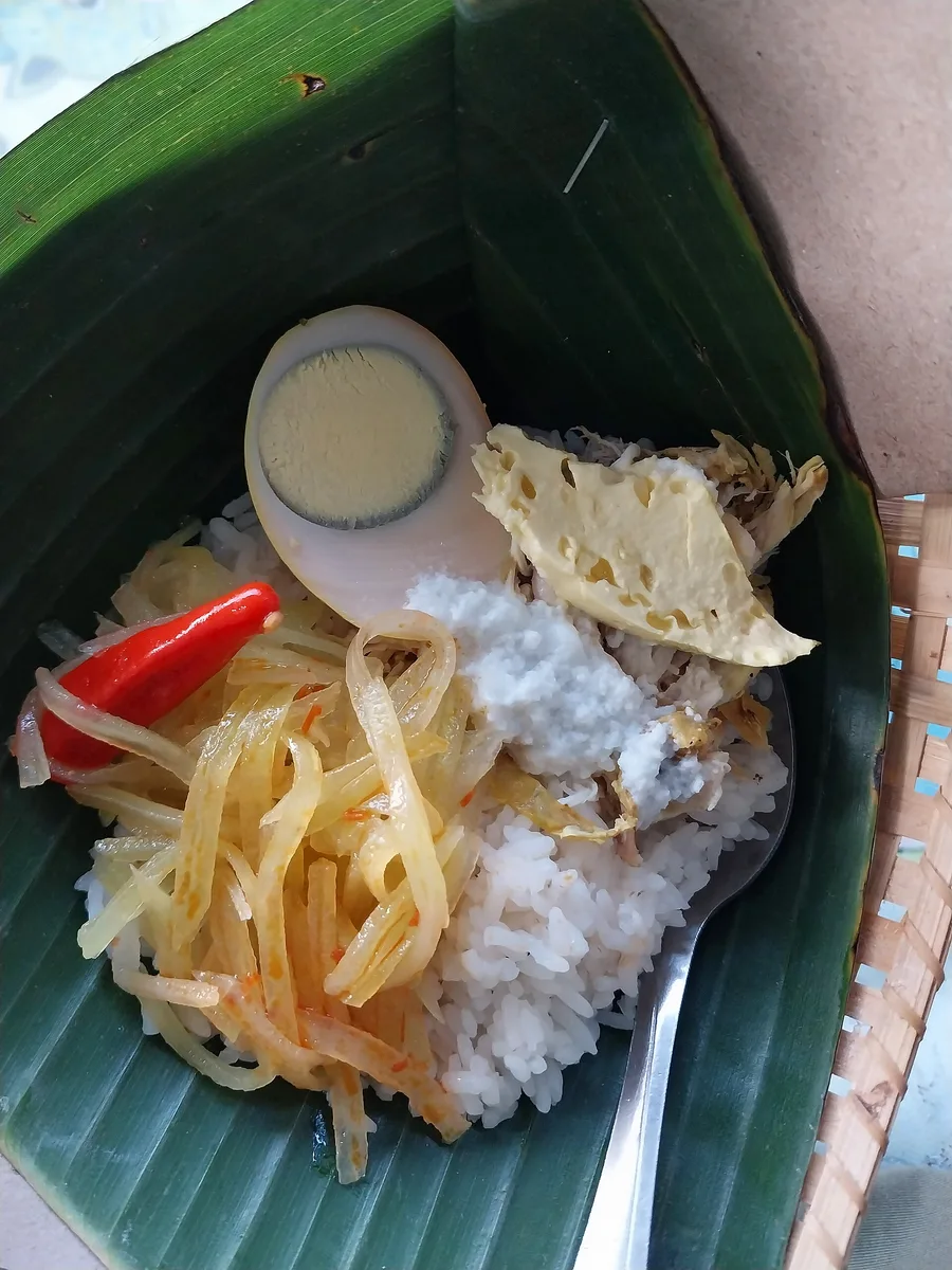 Sepiring nasi liwet Solo di atas pincuk daun pisang berisi nasi gurih, telur pindang, sambal goreng labu siam, suwiran ayam, dan areh santan kental