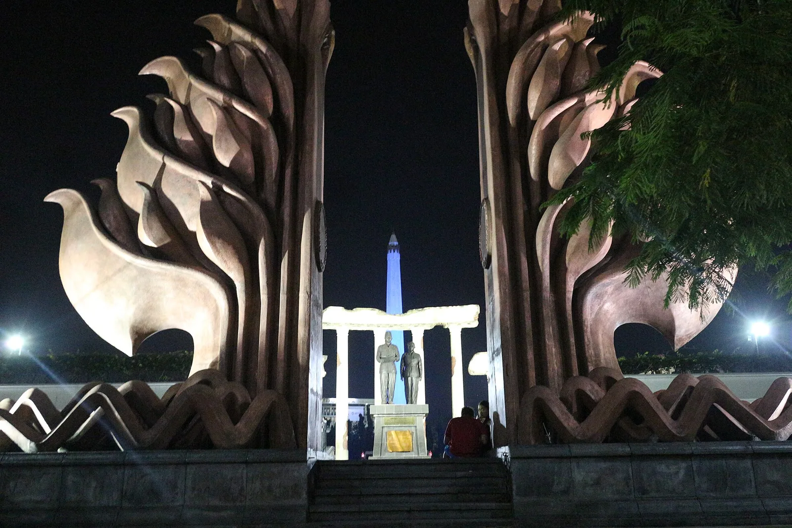 Monumen Tugu Pahlawan Surabaya menyala di malam hari dengan patung Sukarno dan Hatta serta relief berbentuk lidah api di sisi kiri dan kanan